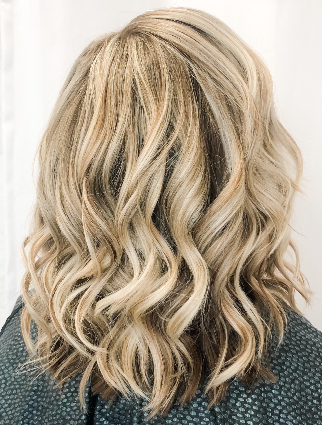 Layered blonde waves with a soft shadow root