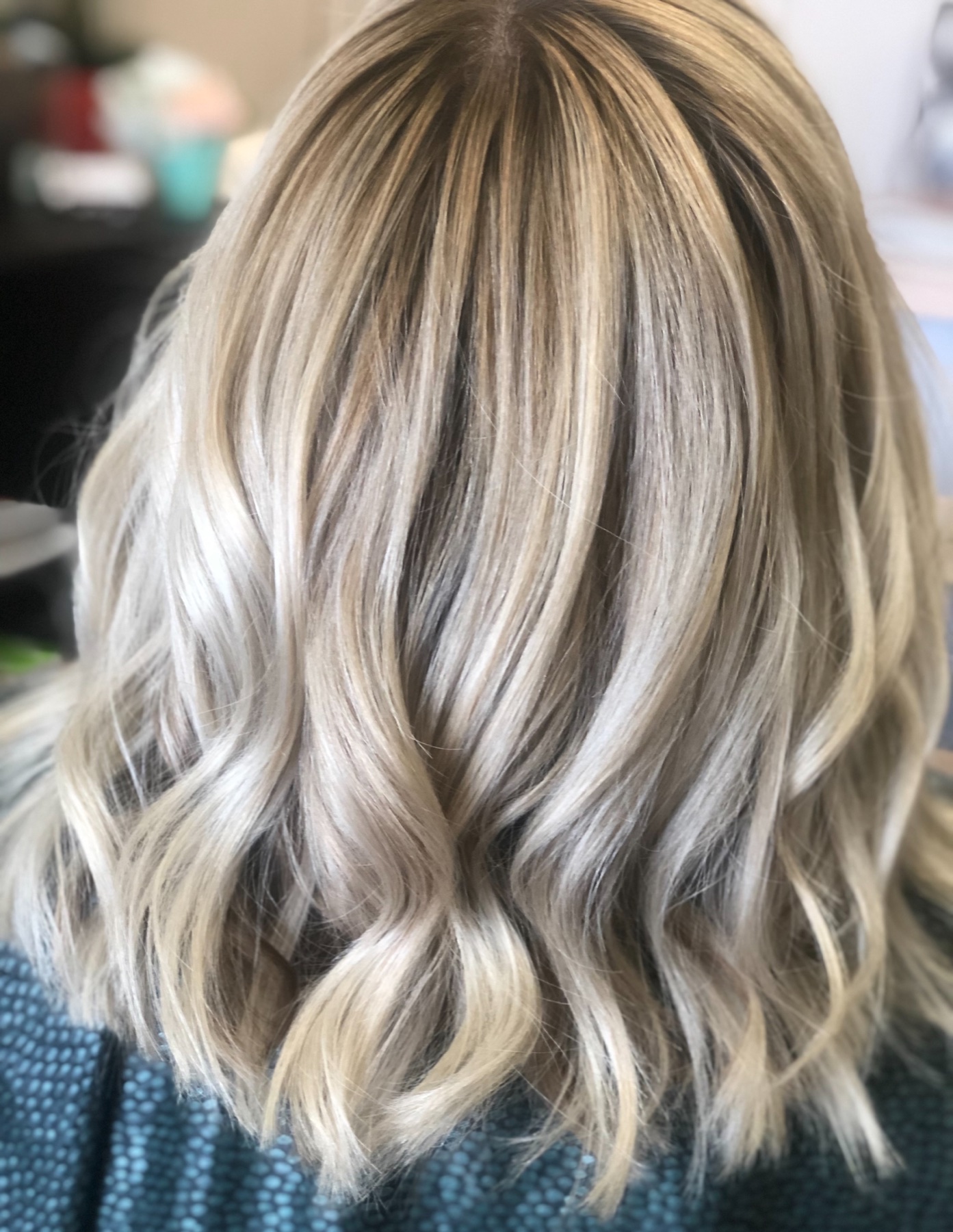 Shoulder length cool blonde waves with a shadow root