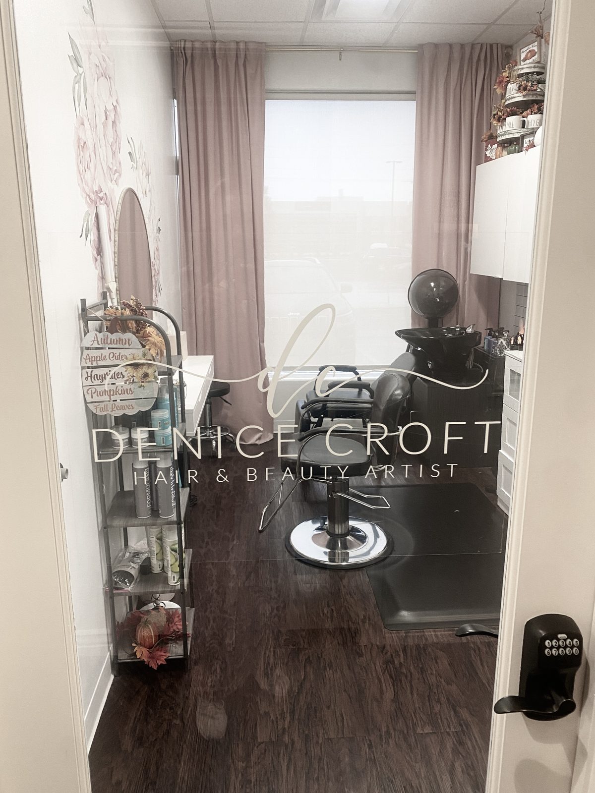 Glass door of Denice Croft's private salon suite, etched with her logo, looking in at the styling chair and shampoo bowl